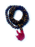 Tibetan coffee bone mala coiled showing full bead detail